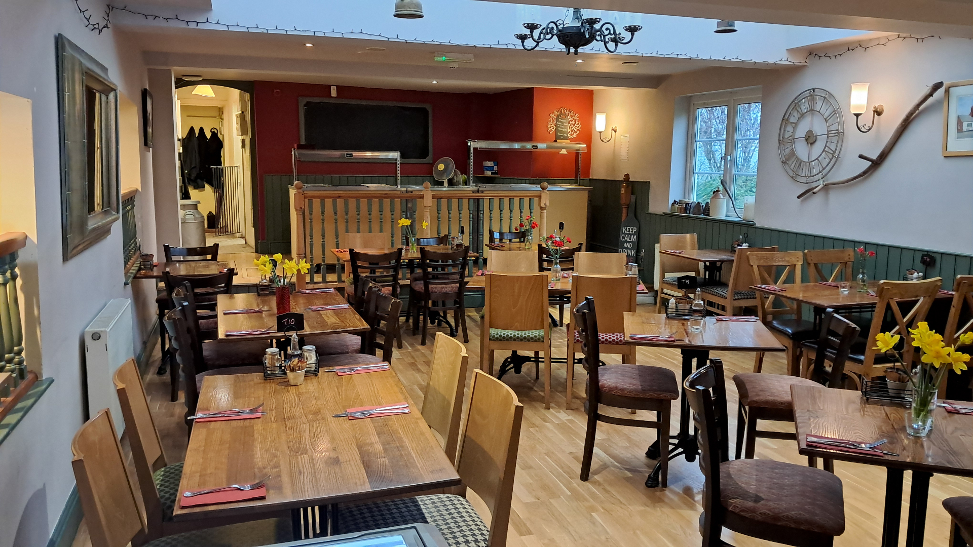 Spacious dining area with wooden tables, carvery station and large wall clock